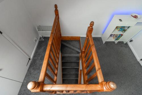 a staircase with a wooden railing in a room at Stylish 3 BD | Prime Location | Fast train to London in Bickley