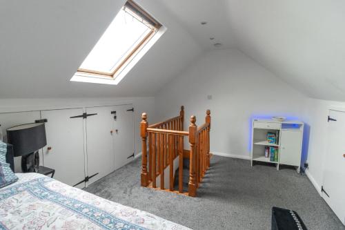 a attic bedroom with a bed and a skylight at Stylish 3 BD | Prime Location | Fast train to London in Bickley