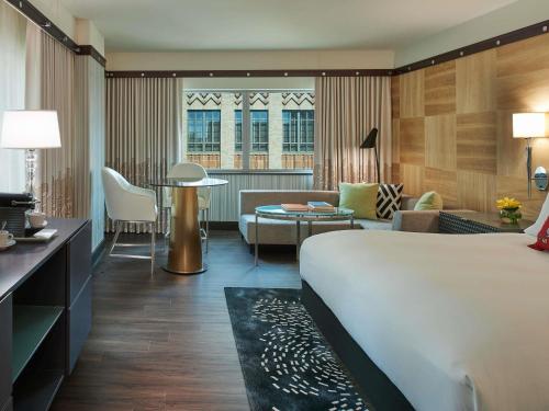 a hotel room with a bed and a living room at Sofitel Philadelphia at Rittenhouse Square in Philadelphia