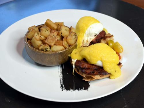 Un plato blanco con un sándwich y un bol de patatas. en Sofitel Philadelphia at Rittenhouse Square, en Filadelfia