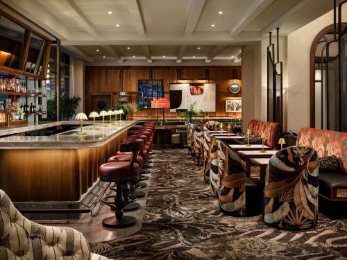 a restaurant with a bar with tables and chairs at Sofitel Philadelphia at Rittenhouse Square in Philadelphia