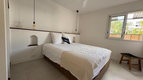a white bedroom with a bed and a window at Le Veloutier by Hestia LCD, 1 chbre avec SPA privé in Bois de Nèfles