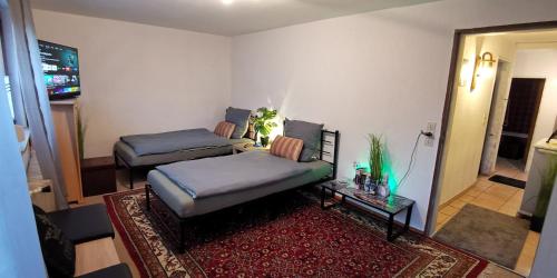a living room with two beds and a table at Komfort 4 Zimmer Ferienwohnung in Kassel, mit eigener Küche, Badezimmer und WC, inkl Gratis Frühstück, Parkplätze, Free WiFi, Smart TV, Top Lage in Kassel in Kassel