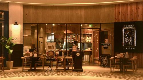 Un restaurante con mesas y sillas en una sala. en Heart of Makati, Fully furnished condo, cbd central location, en Manila