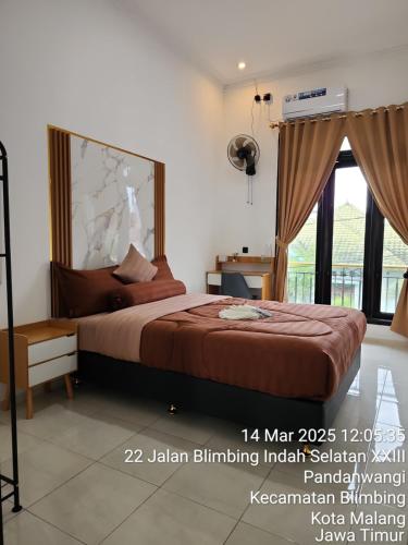 a bedroom with a bed and a large window at Neomi Homestay Malang in Wendit