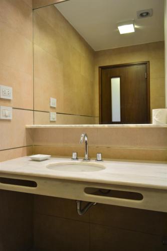 a bathroom with a sink and a mirror at Howard Johnson Hotel Yerba Buena in Yerba Buena