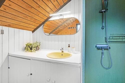 a bathroom with a sink and a wooden ceiling at Stay in nature by the lake, Legoland, Unique nature cabin in Ansager