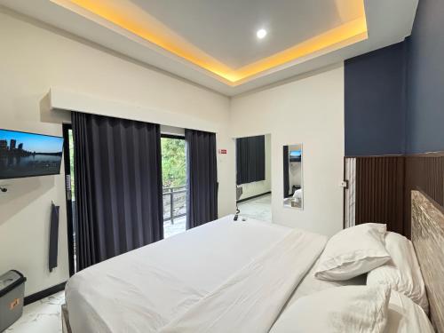 a bedroom with a large bed and a tv at Hostel Labuan ORA in Labuan Bajo