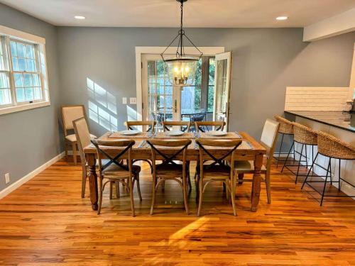 a dining room with a wooden table and chairs at Haven on Glynn by Rove Travel - Coastal Luxury in Shelter Island Heights