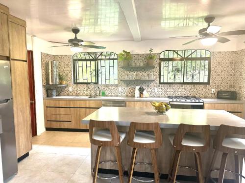 a kitchen with a table and four stools at Tropical Oasis in Ojochal in Ojochal