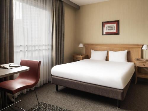 une chambre d'hôtel avec un lit, un bureau et une fenêtre dans l'établissement Aparthotel Adagio La Défense Esplanade, à Puteaux
