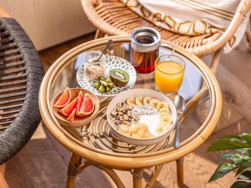 una mesa de cristal con alimentos para el desayuno y bebidas. en ibis Styles Aix les Bains Domaine de Marlioz, en Aix-les-Bains