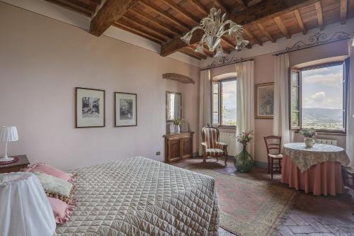 Un dormitorio con una cama y una mesa y ventanas. en Maison Naldi, en Montecarlo