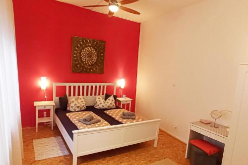 a bedroom with a bed with a red wall at 2Bed Old Town Apt Sleeps 6 - Rooftop Terrace Wifi in Cochem