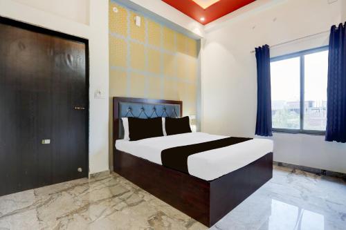 Un dormitorio con una cama grande y una ventana grande en Hotel O Om Sai inn, en Prayagraj