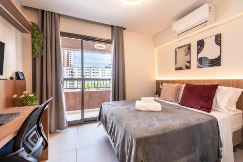 a bedroom with a bed and a desk and a window at Edificio Le Petit - Próx Metrô Vila Mariana in Sao Paulo