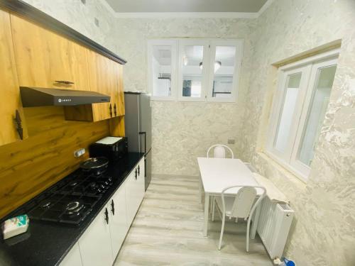 a small kitchen with a table and a stove at Mellinium apartment in old city in Bukhara