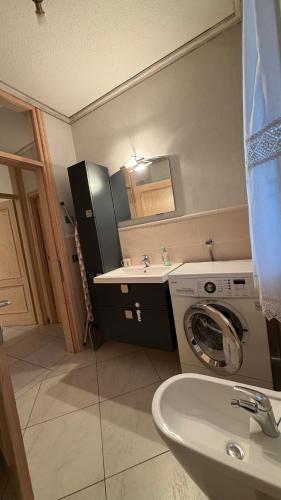 a bathroom with a washing machine and a sink at Appartamento Elena in Santo Stefano di Cadore