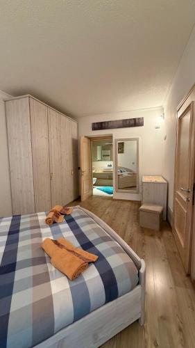 a bedroom with a bed with a blue and white checkered blanket at Appartamento Elena in Santo Stefano di Cadore