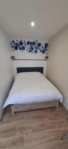a bedroom with a bed with a blue and white wall at Le Cabanon du Marché in Audenge
