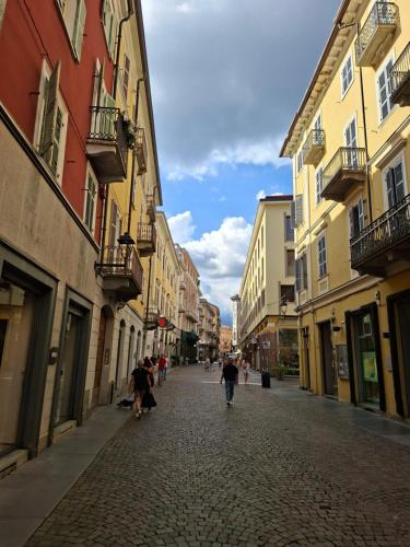 a street with people walking down a cobblestone street at Appartamento Via Italia Centro Biella in Biella