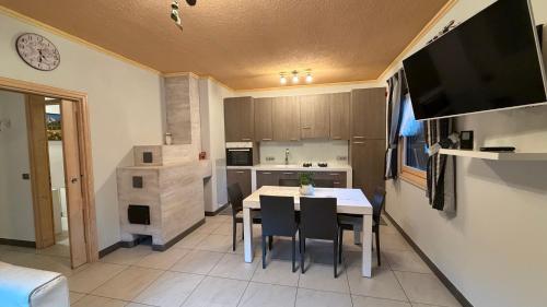 una cucina e una sala da pranzo con tavolo e sedie di Appartamento Elena a San Niccolò Comèlico