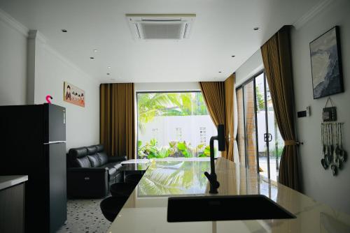 a kitchen and living room with a glass table at Biển Tôm ốc Homestay - Hồ Bơi & BBQ Garden 