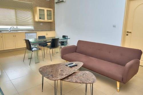 a living room with a couch and a table and chairs at Appartement moderne et lumineux au centre-ville in La Celle-sous-Gouzon