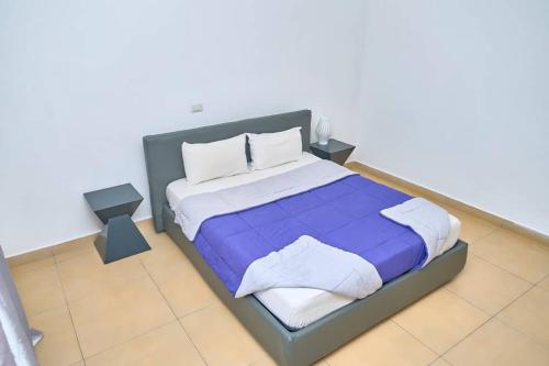 a bedroom with a large bed with purple sheets and pillows at Appartement moderne et lumineux au centre-ville in La Celle-sous-Gouzon