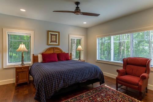 Un dormitorio con una cama y una silla y ventanas. en Longview at Eagles Nest, en Elk Park