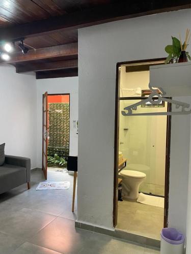 a living room with a toilet and a mirror at Pousada Mandala em frente a Praia da Concha in Itacaré