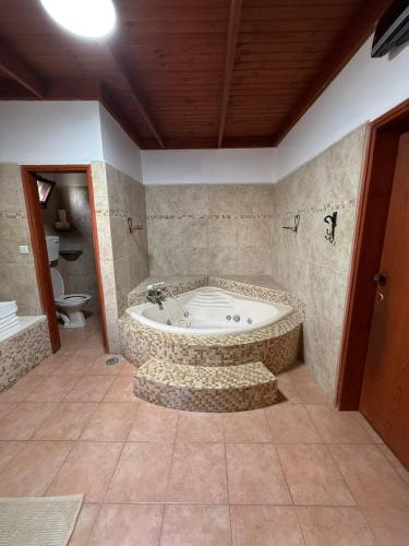 a bathroom with a tub in a room with a toilet at Country house in Golan in Kidmat Tsvi