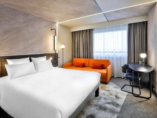 a hotel room with a large bed and a couch at Novotel Praha Wenceslas Square in Prague