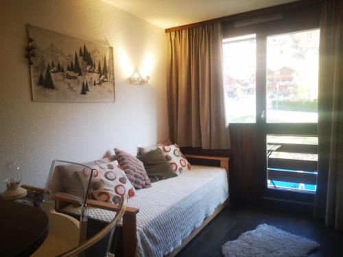 ein kleines Schlafzimmer mit einem Bett und einem Fenster in der Unterkunft Cosy studio in Serre Chevalier in Saint-Chaffrey