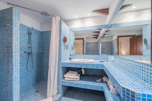 La salle de bains est pourvue de carrelage bleu, d'une baignoire et d'un lavabo. dans l'établissement Sa Llimonera de Binissalem, à Binissalem