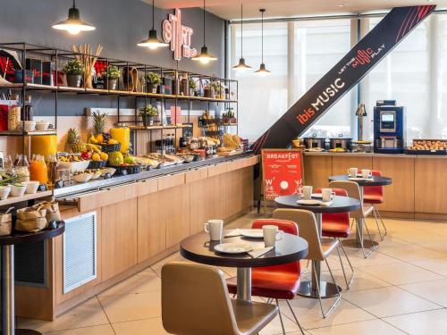 a restaurant with two tables and a counter with food at Ibis Barcelona Meridiana in Barcelona