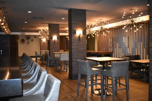 a restaurant with chairs and tables and tables and tablesktop at DoubleTree by Hilton Chicago - Oak Brook in Oak Brook