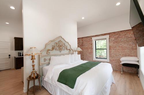 a bedroom with a large white bed and a brick wall at The Suites of Lava Hot Springs in Lava Hot Springs