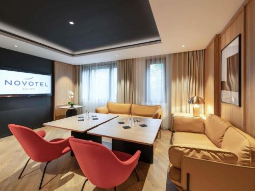 a living room with a table and chairs and a couch at Novotel Suites Paris CDG Airport Villepinte in Roissy-en-France