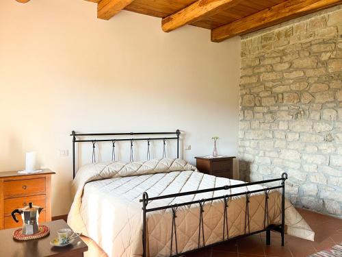 a bedroom with a bed and a stone wall at Le Conche country house in Villamaina