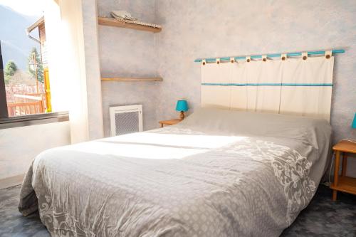 a bedroom with a bed with a white bedspread at Chalet à Aulus-Les-Bains in Aulus-les-Bains