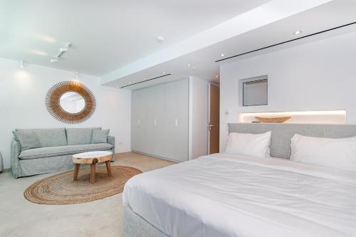 a bedroom with a large white bed and a couch at VistaWave Sea View Villa in Gialova