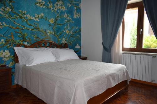 Un dormitorio con una cama con una pared azul. en Villa Francesca Luxury Rooms, en San Demetrio Corone