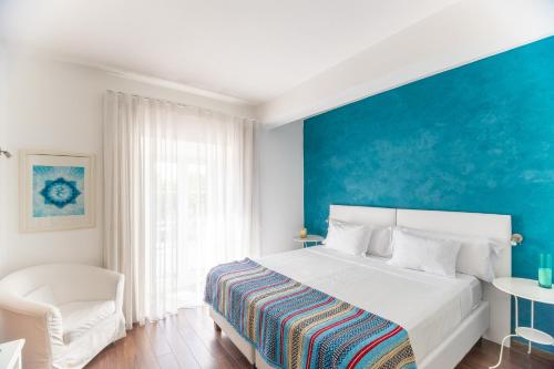 a bedroom with a white bed and a blue wall at Casa do Plátano - Arraiolos in Arraiolos
