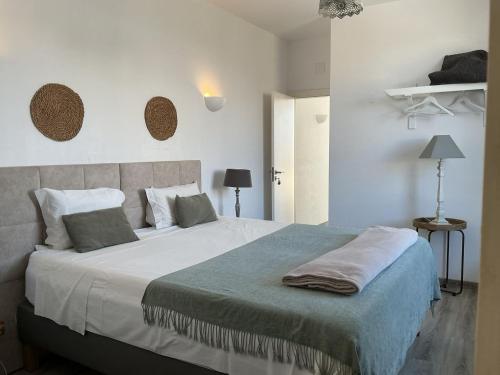 a bedroom with a large bed with white walls at Casa Amarela_ Alojamento Local in Mértola