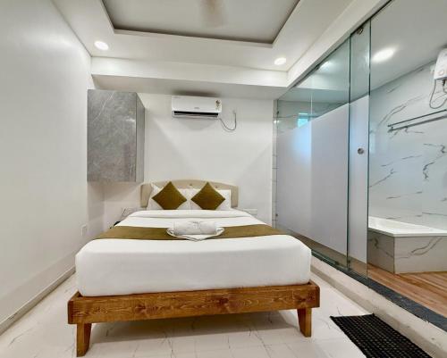 a bedroom with a bed and a glass shower at Hotel Aaditya Inn in Hinjewadi