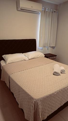 a bed with two towels on it in a bedroom at Amplia y Moderna Casa, en inmejorable ubicación in Ciudad del Este