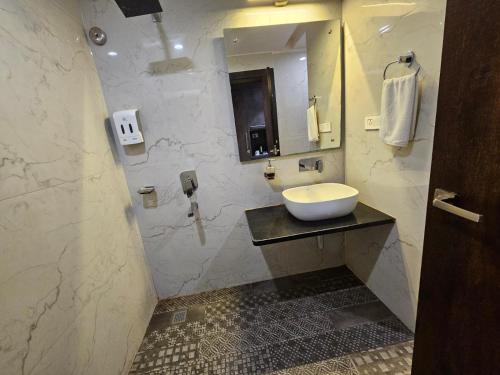 a bathroom with a sink and a mirror at Hotel Abhinav International in Varanasi