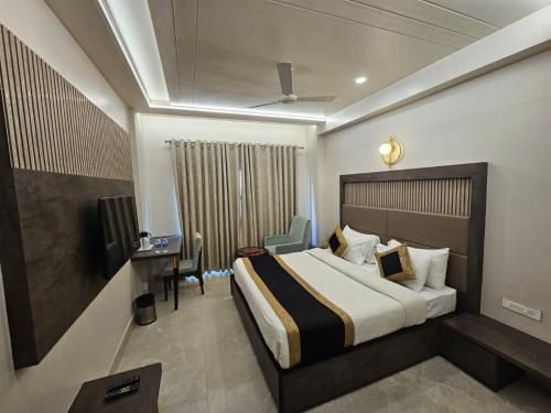 a hotel room with a bed and a desk and chair at Hotel Abhinav International in Varanasi