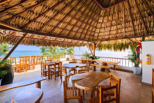 an outdoor restaurant with tables and chairs and the ocean at Cabaña en condominio frente al mar #10 in Tolú